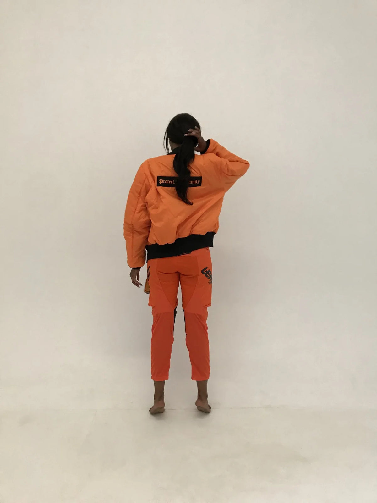 Protect The Family bomber worn orange side out, back view, lookbook 2017